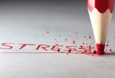 olovka koja ispisuje crvenim slovima stres